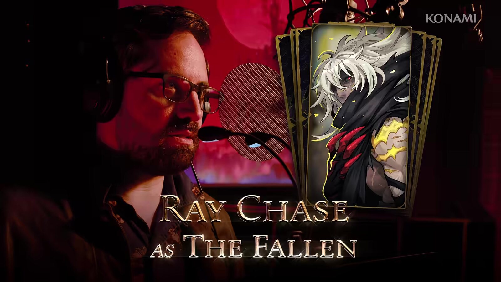 Ray Chase, who voices The Fallen, in a recording booth beside the character's card, from Konami's English voice cast trailer. Image: Konami