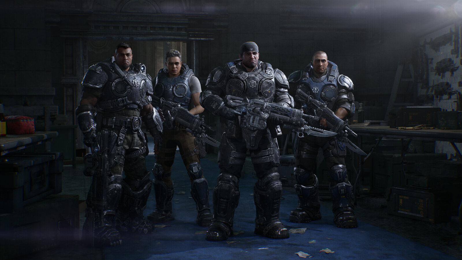 Four COG soldiers in heavy armour stand together in a dim workshop in Gears of War: E-Day. Image: Xbox Game Studios
