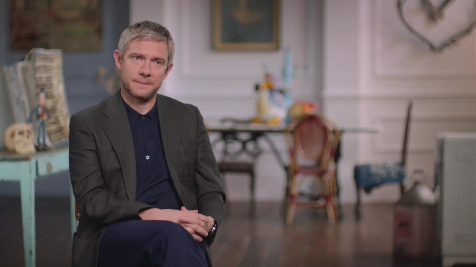 Martin Freeman, con saco oscuro, habla en un set de Aardman en el documental del estudio A Grand Night In, en el canal oficial de Wallace y Gromit. Imagen: Aardman