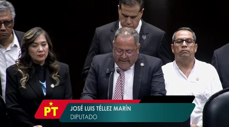El diputado José Luis Téllez Marín, del PT, habla en la tribuna de la Cámara de Diputados de México con otros diputados de pie detrás de él durante la sesión del 7 de octubre de 2026, un fotograma de la transmisión en vivo de la propia Cámara. Imagen: Cámara de Diputados