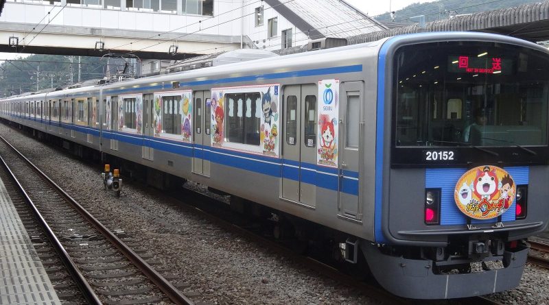A Seibu Railway commuter train wrapped in Yo-kai Watch characters waits at a station platform, with Jibanyan on the front. Photo: 正和, CC BY-SA 4.0