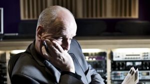 Peter Dickson reading a script at a mixing desk in a recording studio. Image: Peter Dickson media pack
