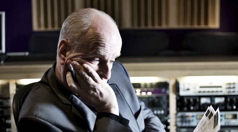 Peter Dickson reading a script at a mixing desk in a recording studio. Image: Peter Dickson media pack