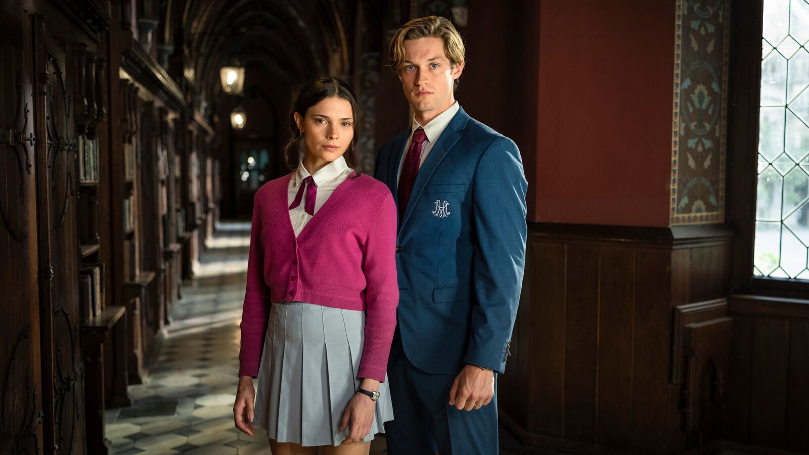 Harriet Herbig-Matten as Ruby and Damian Hardung as James standing side by side in school uniform in a wood-panelled corridor, in a first-look image from Season 3 of Maxton Hall. Image: Prime Video / Stephan Rabold