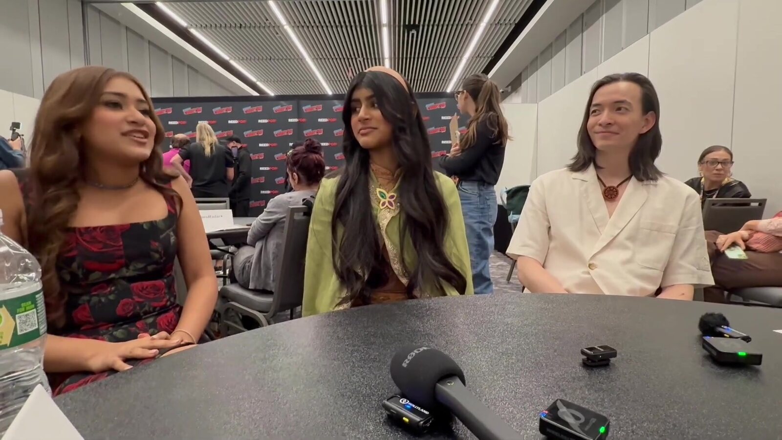 Saheli Khan, Aishu Devan and Major Curda, the voices of Pavi, Nisha and Jae, at a press table at New York Comic Con on premiere day, microphones in front of them. Image: blackfilmandtv