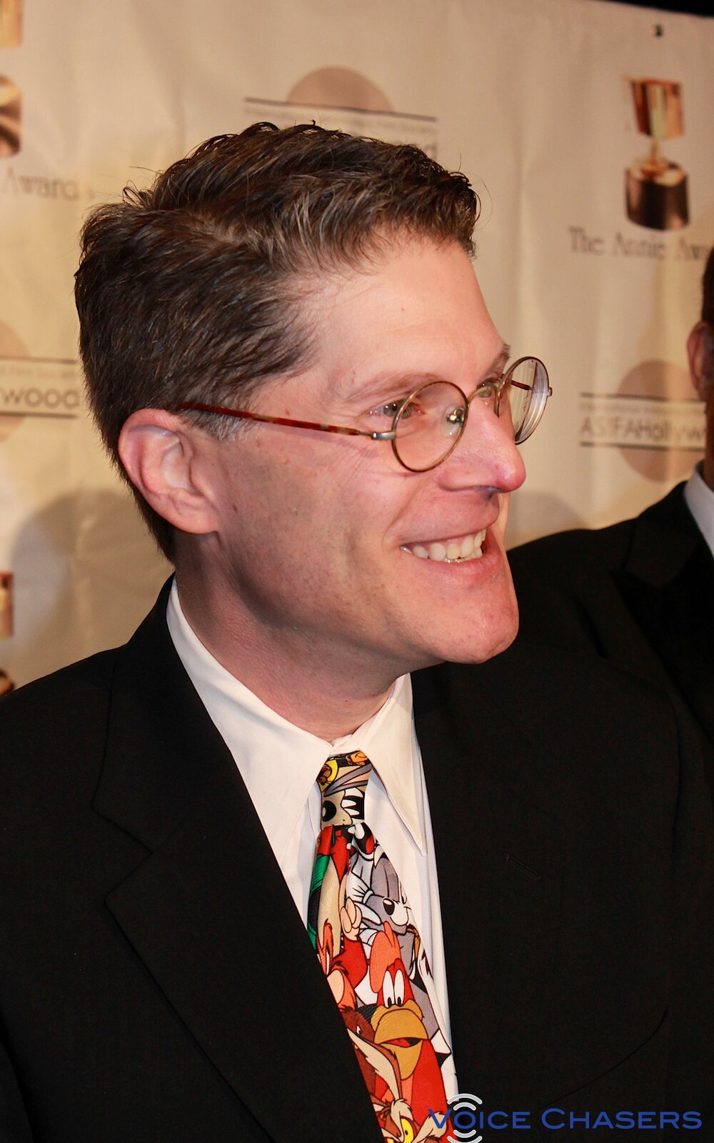 Bob Bergen, co-chair of SAG-AFTRA's TV Animation Negotiating Committee and the voice of Porky Pig, smiling at the 41st Annie Awards in 2014 in a Looney Tunes tie. Image: voicechasers, CC BY 2.0, via Wikimedia Commons