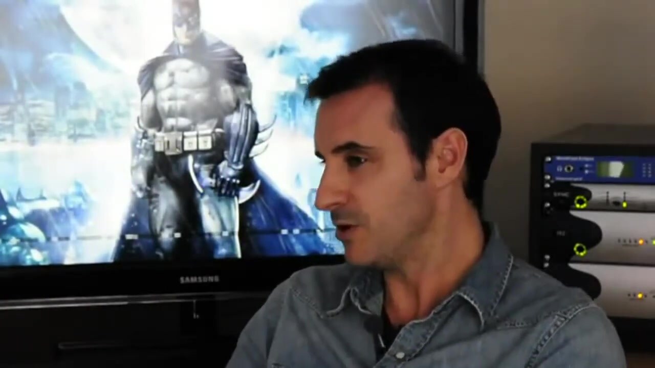 Claudio Serrano sentado en un estudio de doblaje frente a una pantalla con una imagen de Batman, en un fotograma de su propia entrevista en YouTube. Imagen: Claudio Serrano Actor (YouTube)