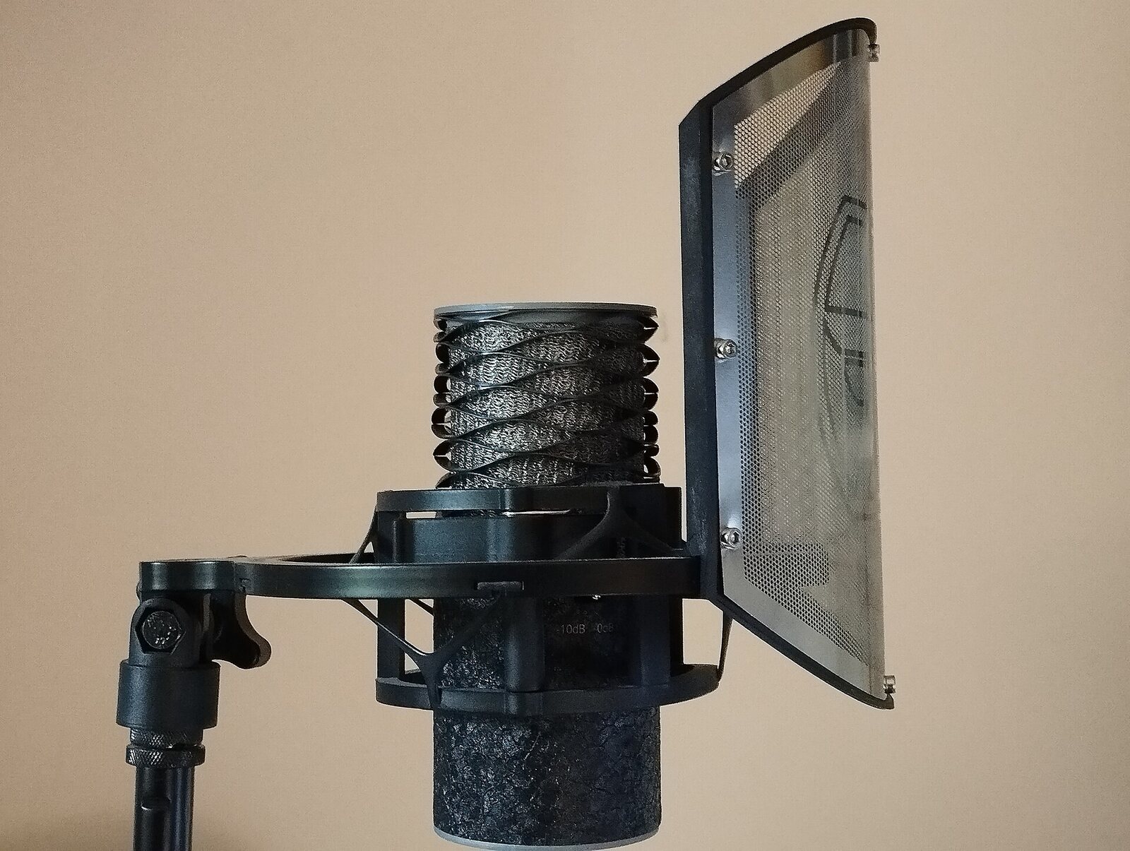Un micrófono de condensador Aston Origin en su suspensión, con un filtro antipop metálico curvo colocado a unos centímetros de la cápsula. Foto: Bizzarle, Wikimedia Commons, CC BY-SA 4.0