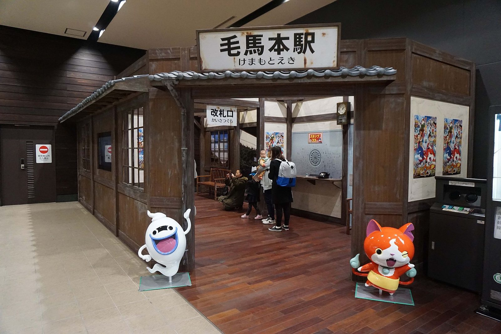 A full-size Yo-kai Watch set of Kemamoto Station, with figures of Whisper and Jibanyan by the entrance and posters on the walls. Image: z tanuki, CC BY 3.0